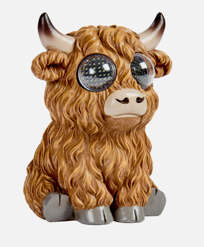 Decorative yak figurine with LED eyes in front of a natural background