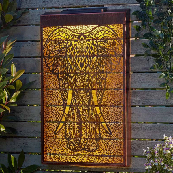 Decorative wall light with elephant design on a wooden surface