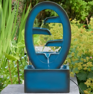 Blue garden fountain with water feature surrounded by greenery