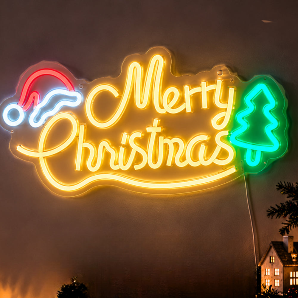 A glowing Christmas neon sign on a dark night sky, with the words “Merry Christmas” in bright yellow, a red and blue Santa hat on the left, and a green Christmas tree on the right.
