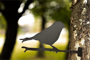 Single bird silhouette metal decoration mounted on garden tree