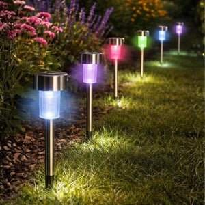 Solar-powered garden lights emitting colorful lights on a grassy area with flowers.