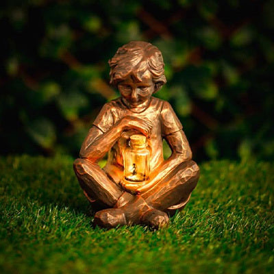 Solar boy garden ornament holding glowing firefly jar
