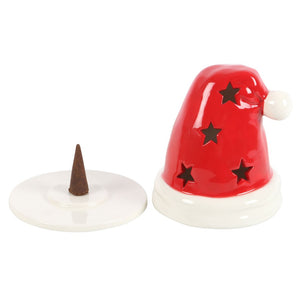 Red bell-shaped object with star designs on a white background with incense cone