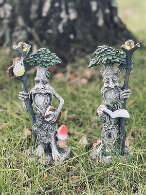 Tree man garden ornaments attached to outdoor tree trunk