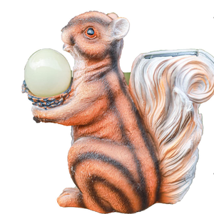 A decorative squirrel figurine holding a pale green orb, shown against a plain white background.