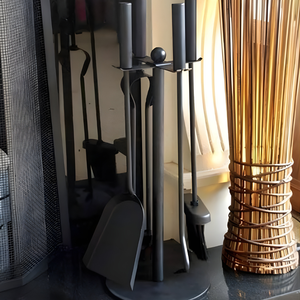 Set of fireplace tools including a poker, brush, and tongs on a stand next to a decorative vase.