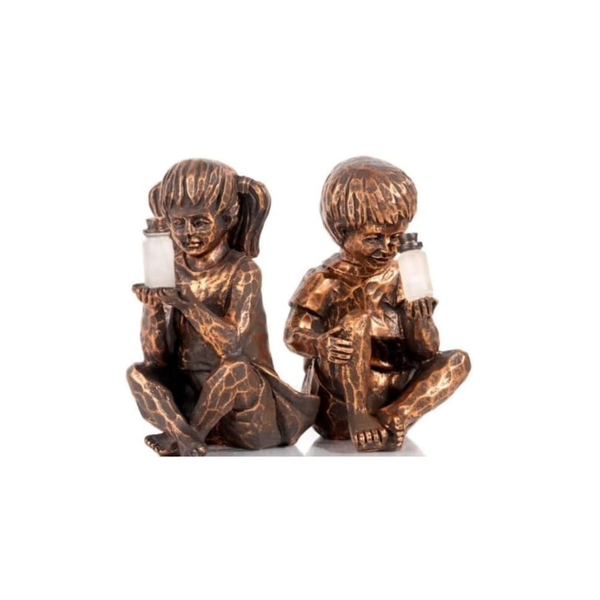 A pair of bronze-finished decorative figurines depicting two children sitting and holding small white candles, set against a plain white background.