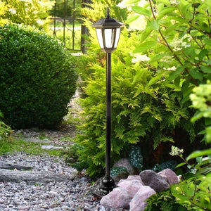 Solar powered Victorian lamp post illuminating garden pathway