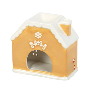 Decorative gingerbread house-shaped candle on a white background