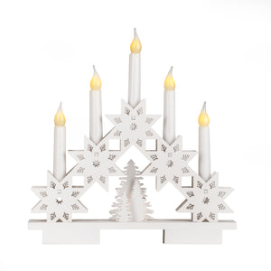 Decorative candle holder with snowflake designs and lit candles on a white background