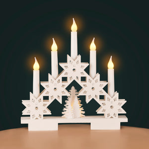 Decorative candle holder with star designs and lit candles on a dark background