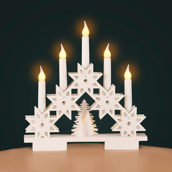Decorative candle holder with star designs and lit candles on a dark background