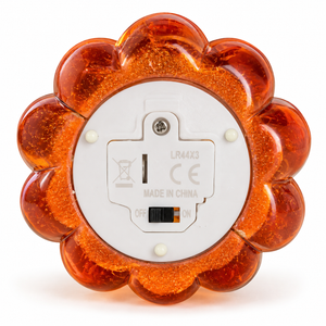 The back of a flower-shaped amber LED night light with a white circular base, featuring a power switch and regulatory markings.