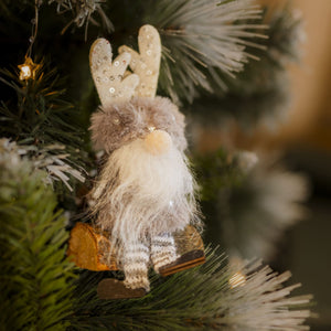 A plush Christmas gonk decoration with a festive design, featuring a character with a grey beard, wearing a hat and gloves, attached to a Christmas tree.