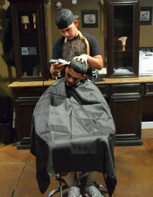 Lightweight barber cape designed to help protect clothing