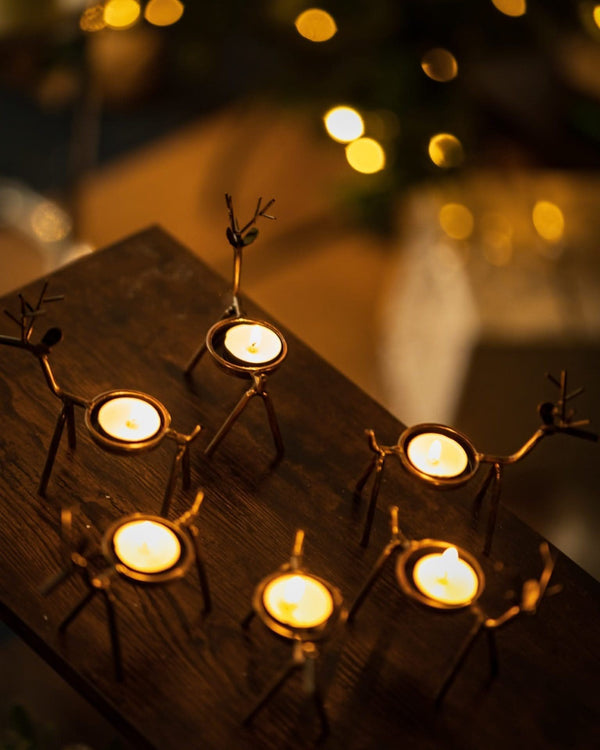 Metal reindeer candle holders displayed on a mantelpiece