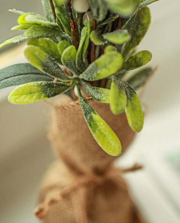 Faux mistletoe Christmas tree displayed in brown jute bag
