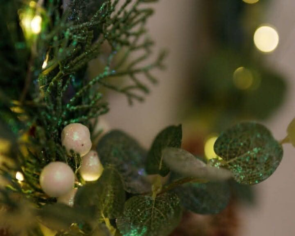 Sage leaves and white berries surrounding a decorative hoop