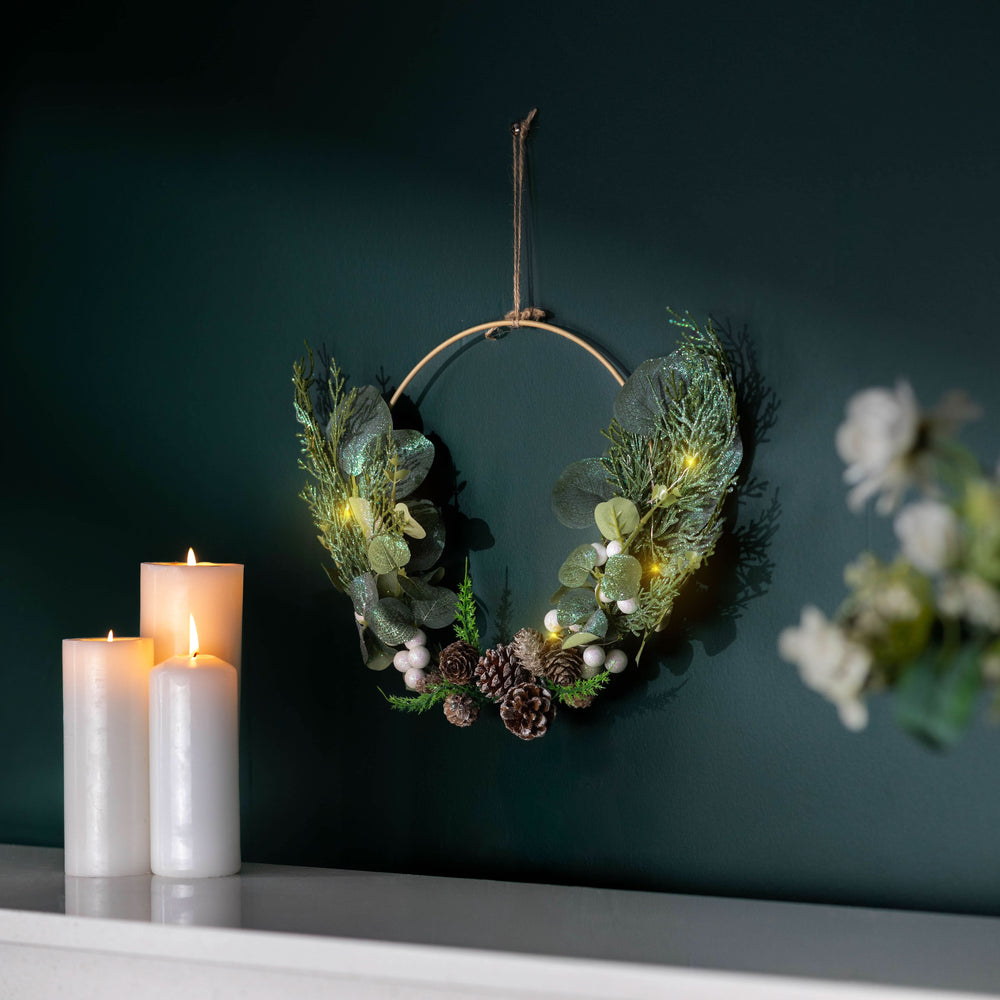 Sage foliage hoop decorated with pinecones and white berries