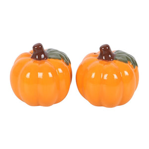Two ceramic pumpkin-shaped salt and pepper shakers on a white background
