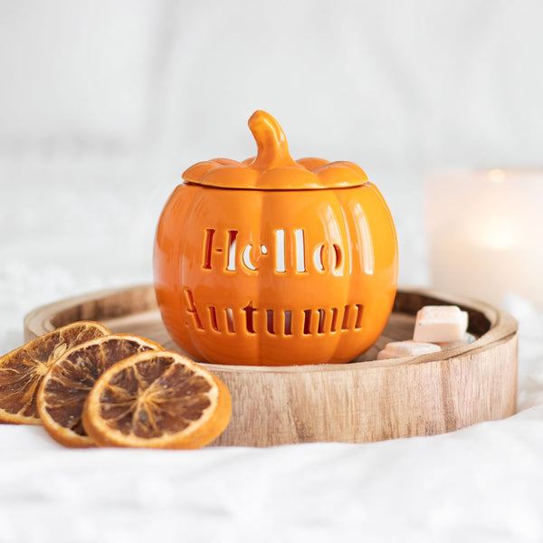Pumpkin oil burner arranged with seasonal decorations