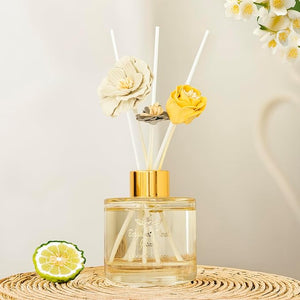 Reed diffuser with floral elements on a neutral background