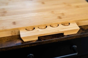 Wooden cutting board with knife slots on a dark surface