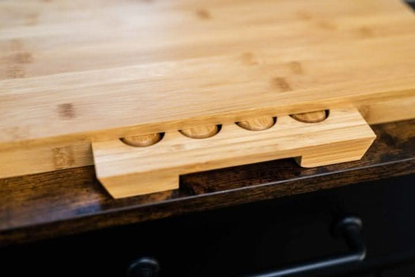 Wooden cutting board with knife slots on a dark surface