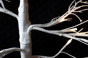 Festive twig tree with realistic silver leaves and lights