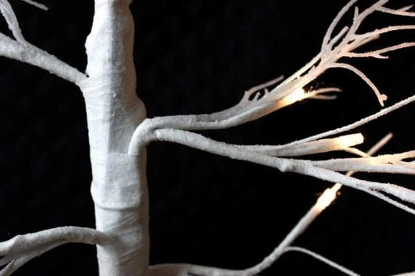 Festive twig tree with realistic silver leaves and lights