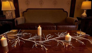 Birch branch lights displayed across a living room mantel