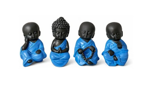 Four Buddha statues displayed together in different poses