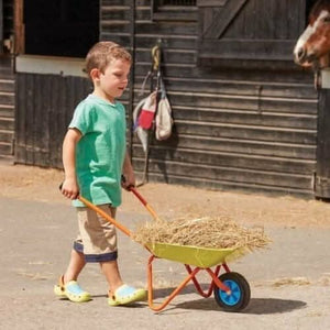 Child size wheelbarrow displayed in garden