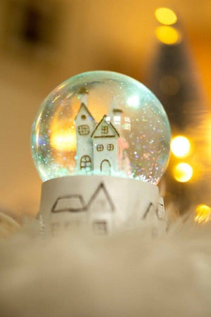 Colour changing Christmas snow globe shown glowing
