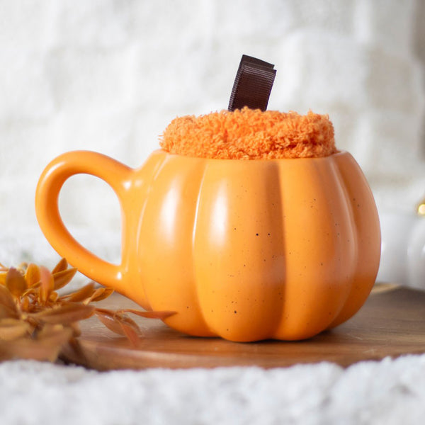 Pumpkin shaped cup displayed with soft one size socks