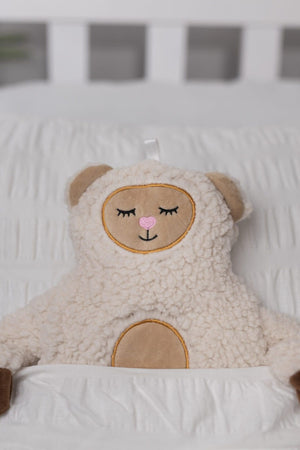 Sheep themed hot water bottle displayed on a bed