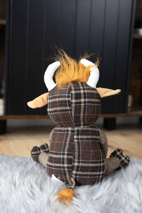 Highland cow weighted doorstop on wooden floor
