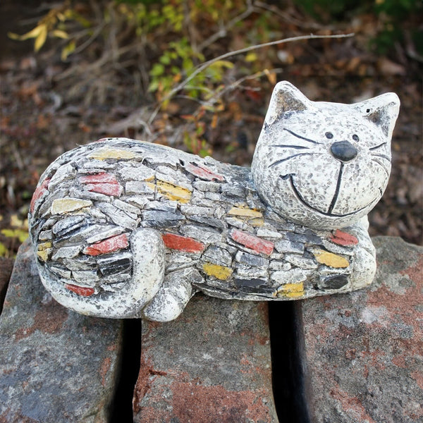Stone look animal ornament positioned in a flower bed