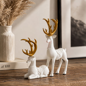 Two reindeer ornaments displayed on a mantelpiece