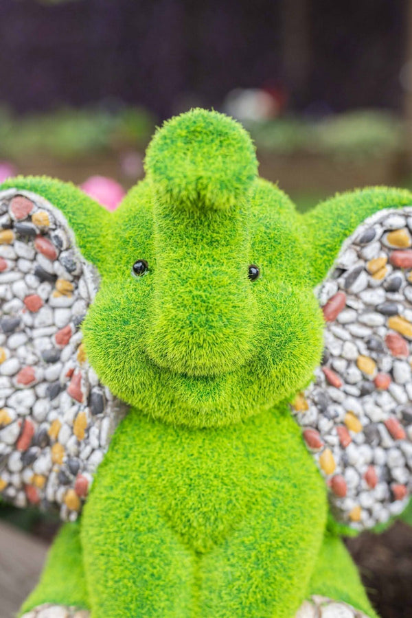 Stone effect elephant ornament beside garden plants