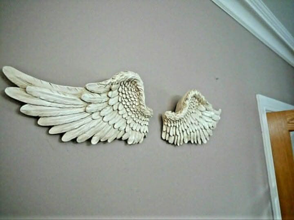 Antique style angel wings decorating a bedroom wall