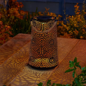Metal outdoor solar lantern on a garden table.