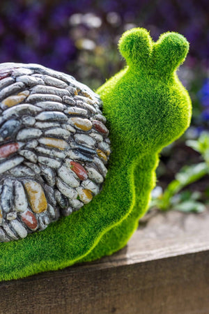 Stone and grass snail ornament displayed on patio