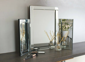 Glass vanity mirror displayed with makeup accessories