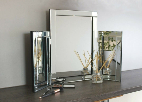 Glass vanity mirror displayed with makeup accessories