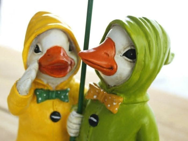 Resin ducks with umbrellas displayed outdoors