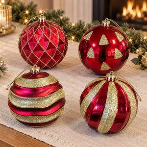 Four oversized red and gold Christmas baubles with different glitter patterns displayed on a festive table.