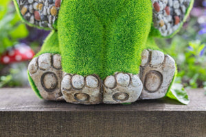 Resin elephant ornament displayed in flower bed