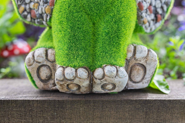Resin elephant ornament displayed in flower bed
